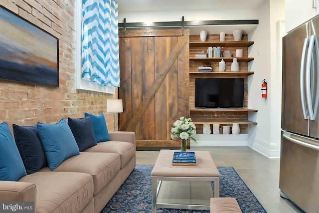 living room with brick wall and a barn door