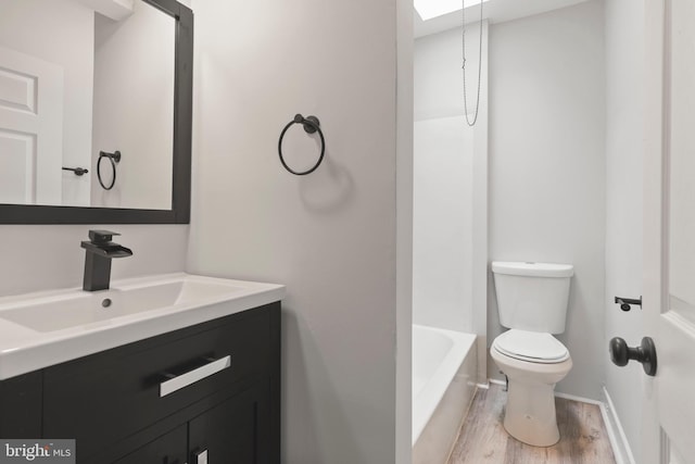 bathroom with wood-type flooring, vanity, and toilet