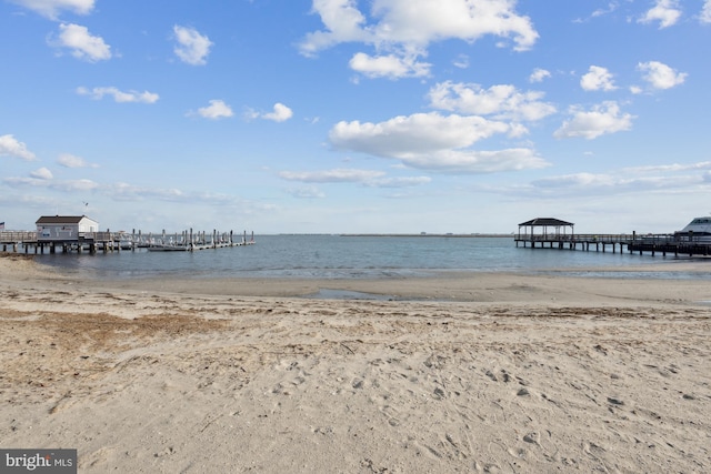 dock area featuring a water view and a view of the beach