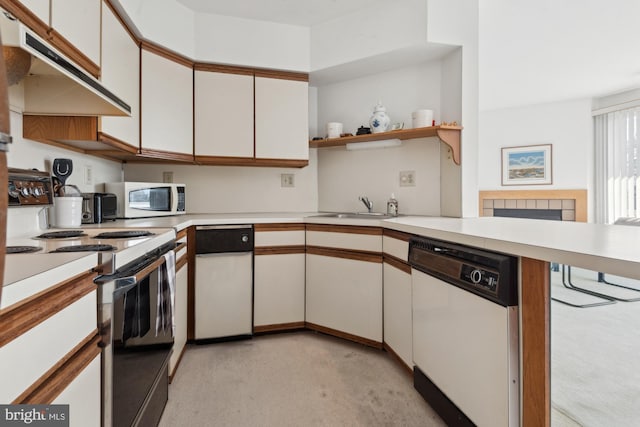 kitchen with white cabinetry, sink, white appliances, and kitchen peninsula