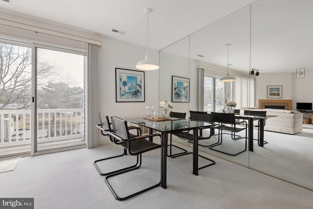 dining room with carpet floors and a fireplace