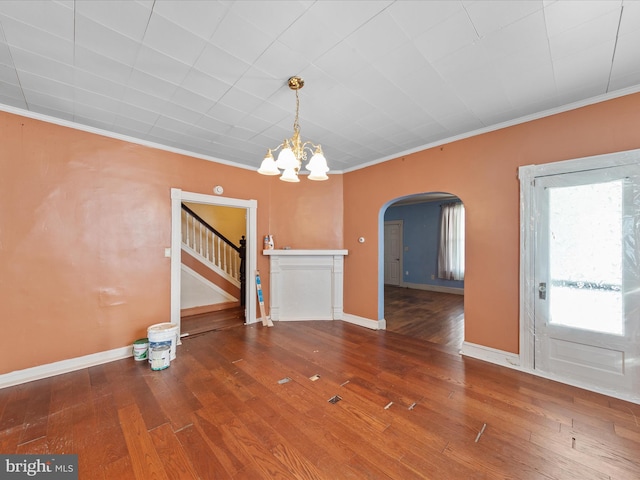 unfurnished dining area with wood-type flooring, ornamental molding, and a chandelier