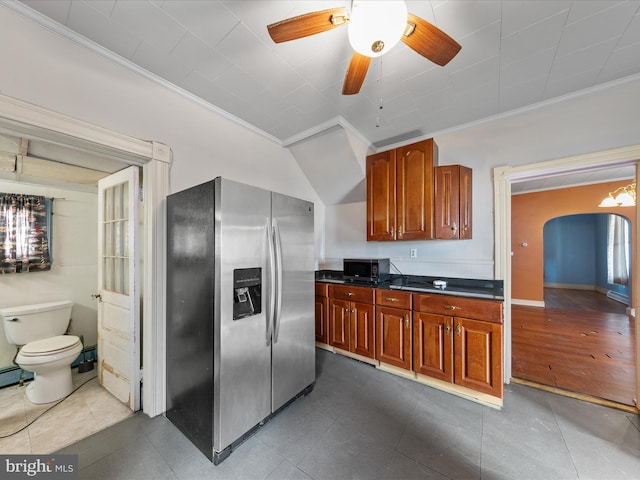 kitchen featuring stainless steel refrigerator with ice dispenser, ceiling fan, crown molding, and dark tile patterned flooring