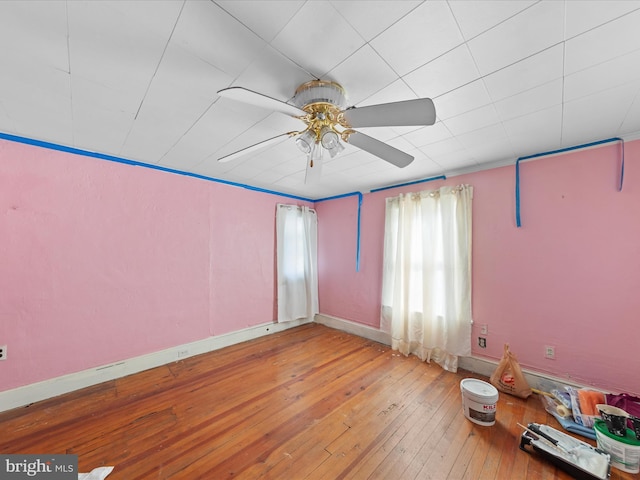 empty room with hardwood / wood-style flooring and ceiling fan