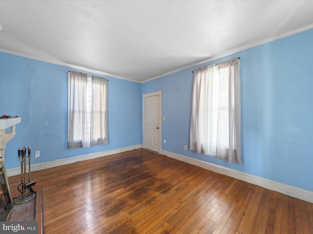 unfurnished living room with crown molding, plenty of natural light, and dark hardwood / wood-style floors