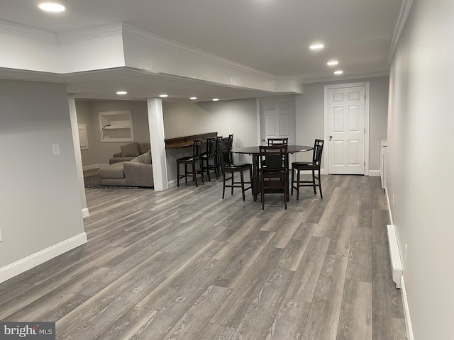 dining room with hardwood / wood-style flooring and crown molding