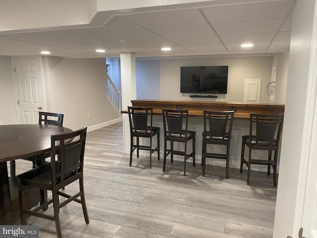 bar with wood-type flooring and a paneled ceiling