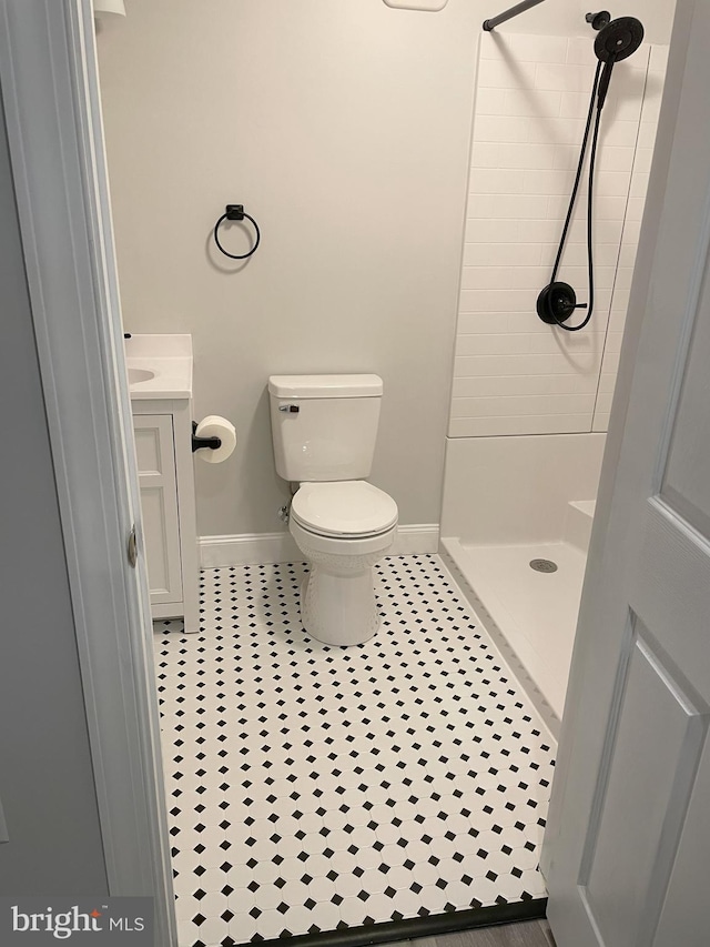 bathroom featuring walk in shower, tile patterned floors, vanity, and toilet