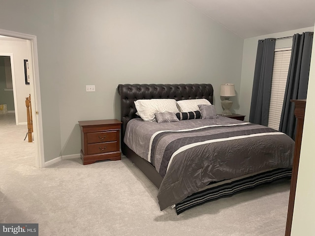 bedroom featuring lofted ceiling and light carpet