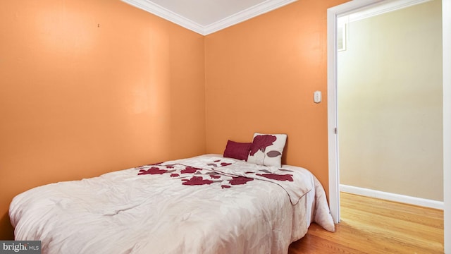 bedroom with crown molding and wood-type flooring