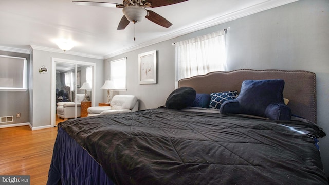 bedroom featuring ceiling fan, ornamental molding, and light wood-type flooring