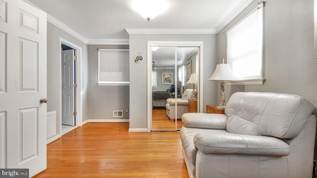 sitting room featuring crown molding and light wood-type flooring