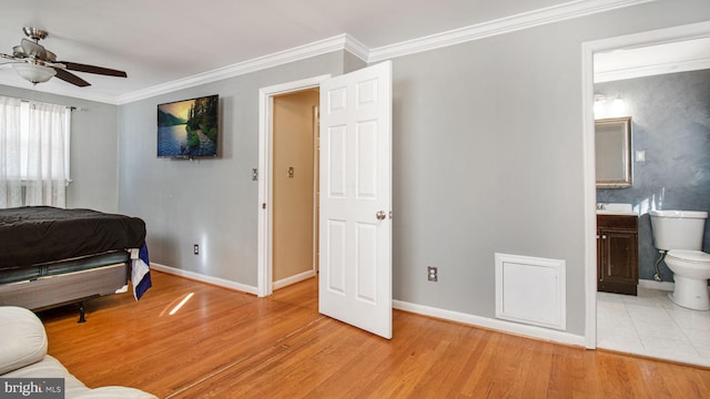 bedroom with connected bathroom, light hardwood / wood-style flooring, and ornamental molding