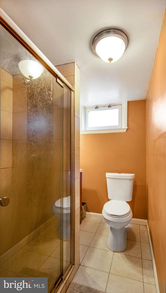 bathroom with tile patterned flooring, toilet, and walk in shower