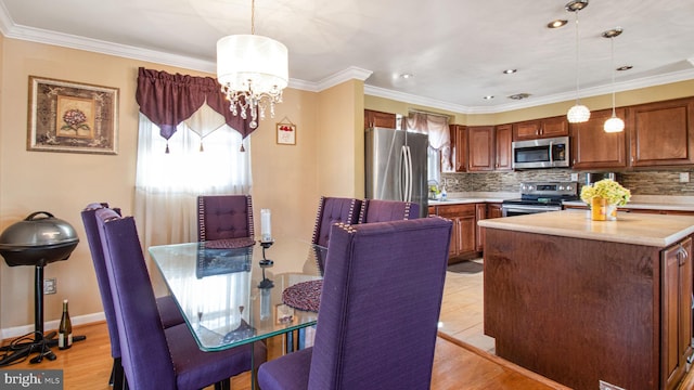 dining room with sink, crown molding, a chandelier, and light wood-type flooring