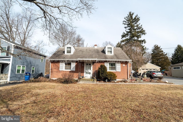 cape cod home with a front yard