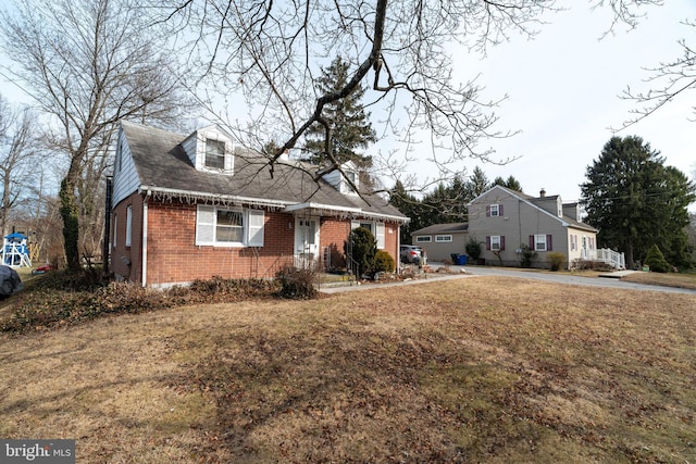 cape cod-style house with a front lawn