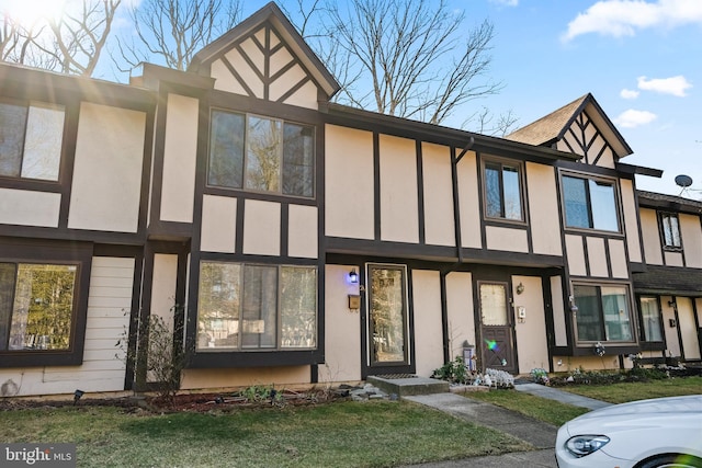 english style home featuring a front yard