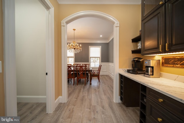 kitchen with arched walkways, open shelves, dark brown cabinets, and crown molding