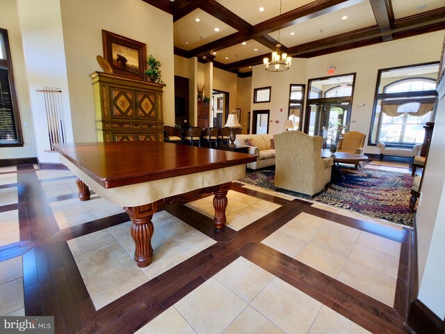 interior space with coffered ceiling, a notable chandelier, beam ceiling, and a high ceiling