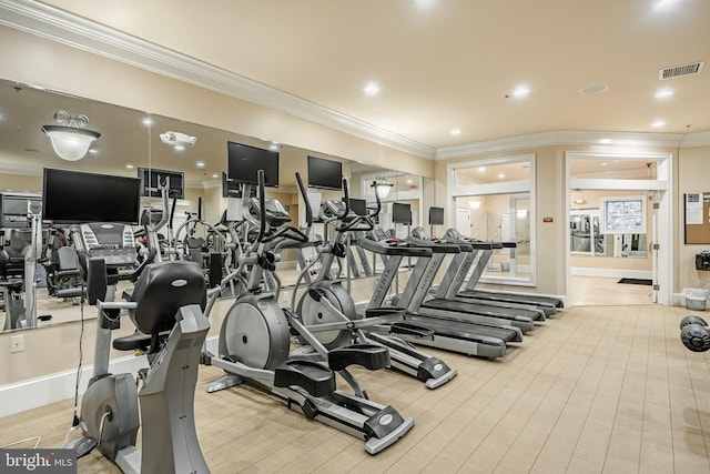 workout area featuring ornamental molding and light wood-type flooring