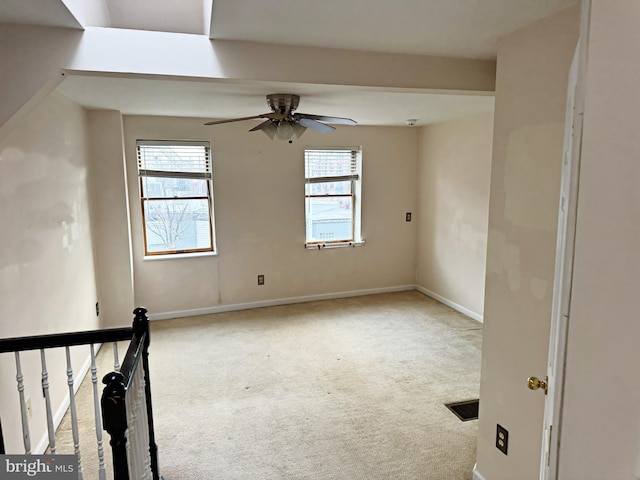 carpeted empty room featuring a wealth of natural light and ceiling fan