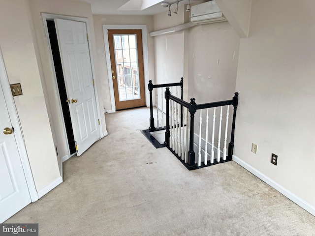 hallway featuring a wall mounted AC and light carpet