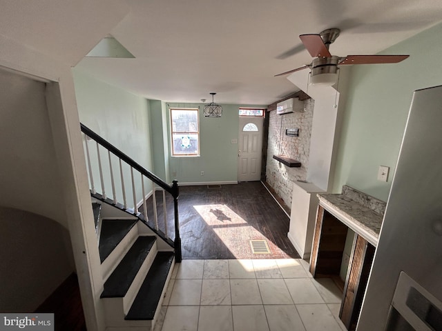 tiled entryway with a wall mounted AC and ceiling fan