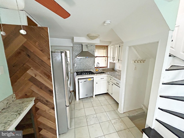 kitchen with sink, wall chimney range hood, white cabinetry, backsplash, and stainless steel appliances