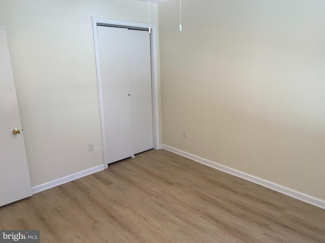 unfurnished bedroom featuring light hardwood / wood-style floors and a closet