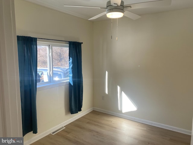 empty room with hardwood / wood-style floors and ceiling fan