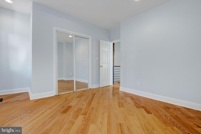 unfurnished bedroom featuring light hardwood / wood-style floors and a closet