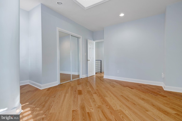 unfurnished bedroom featuring a closet and light wood-type flooring