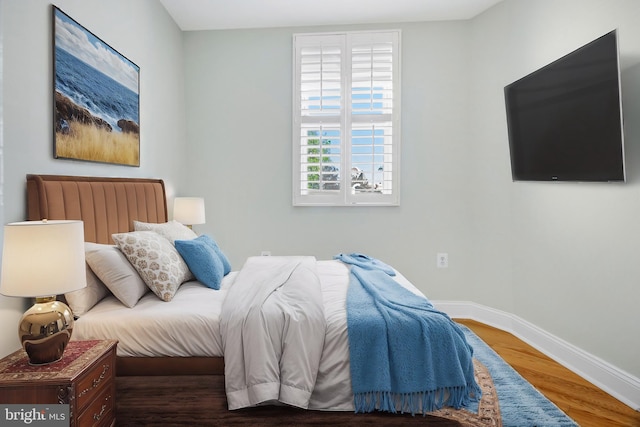 bedroom with hardwood / wood-style flooring and radiator heating unit