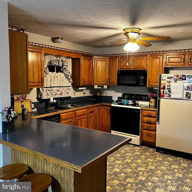 kitchen with sink, range with electric stovetop, kitchen peninsula, white fridge, and ceiling fan