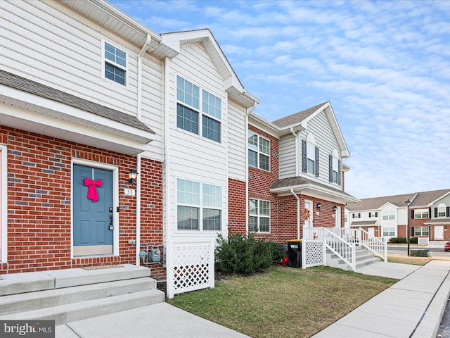 townhome / multi-family property with a front yard