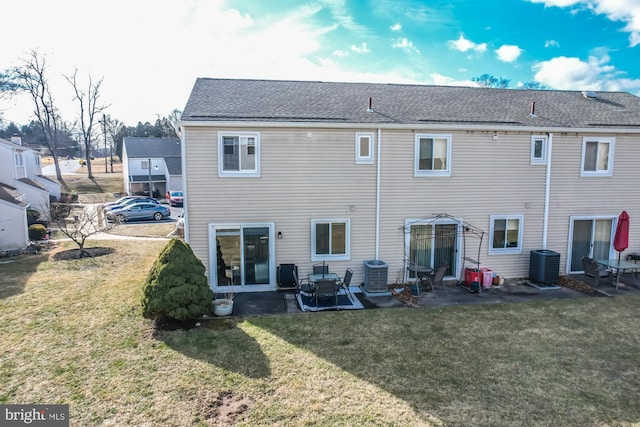 back of property with a patio, central AC unit, and a lawn