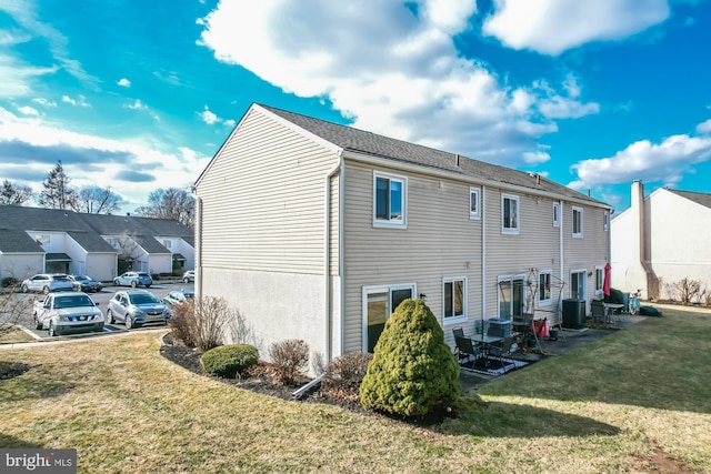 view of property exterior with a yard and central air condition unit