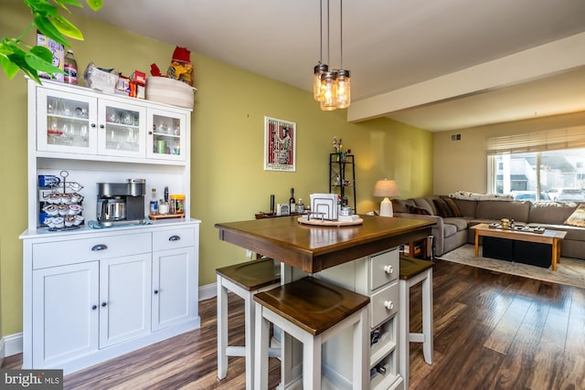 kitchen featuring hanging light fixtures, dark wood-type flooring, and white cabinets