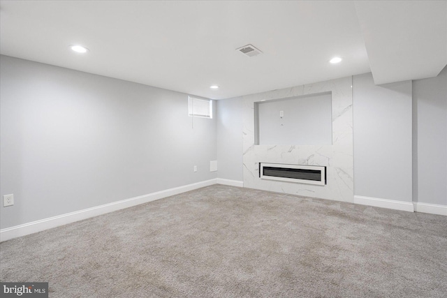 basement with carpet floors and a fireplace