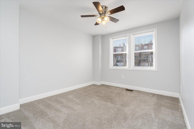 carpeted spare room with ceiling fan