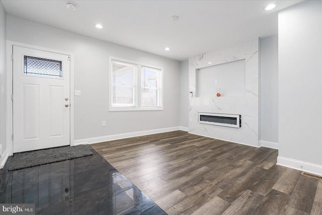 entryway featuring dark hardwood / wood-style flooring and a high end fireplace