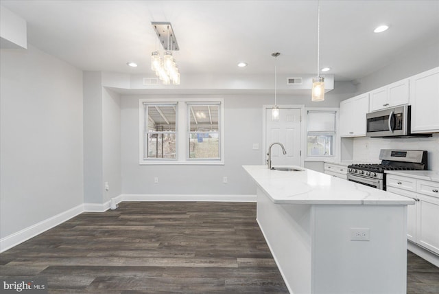 kitchen featuring pendant lighting, sink, white cabinetry, and appliances with stainless steel finishes