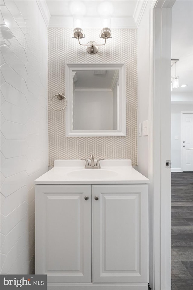 bathroom with hardwood / wood-style flooring, vanity, and crown molding