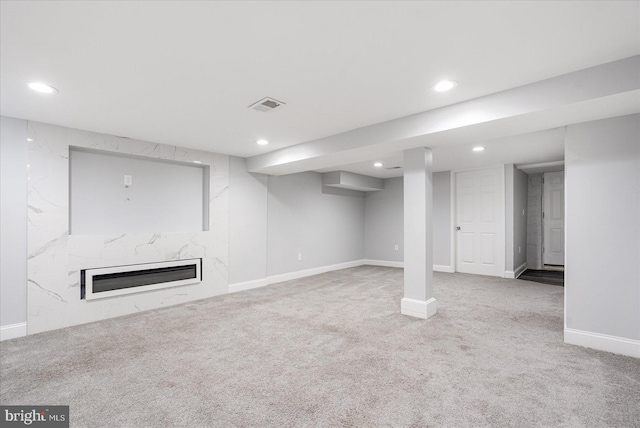 basement with a premium fireplace and carpet flooring