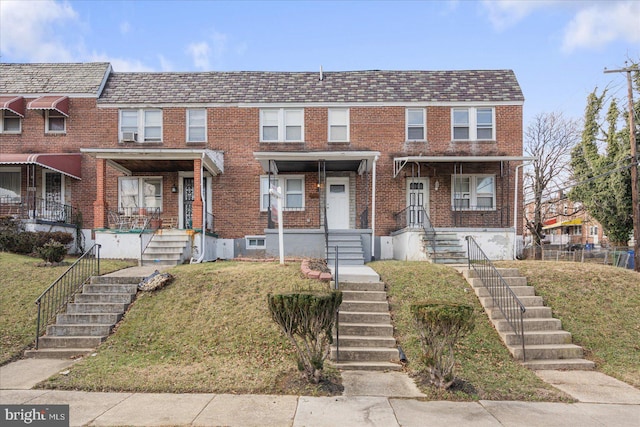 townhome / multi-family property featuring covered porch and a front lawn