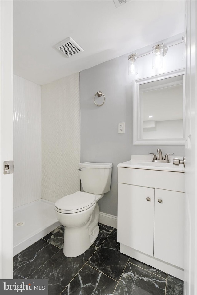 bathroom featuring vanity, a shower, and toilet