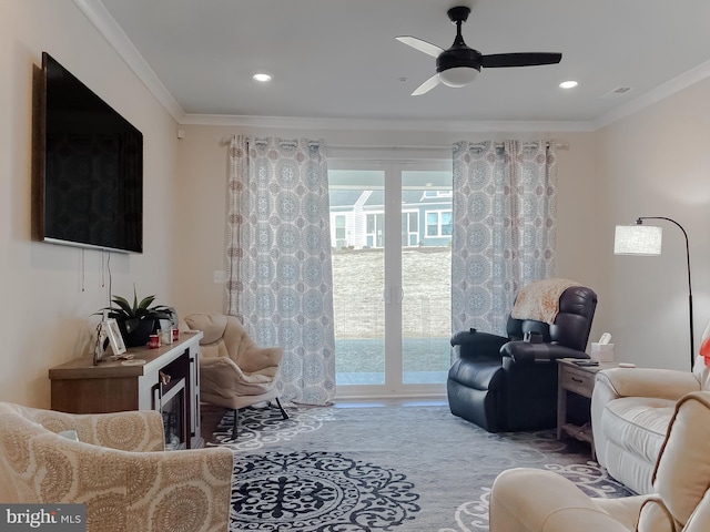 living room with crown molding, plenty of natural light, and ceiling fan