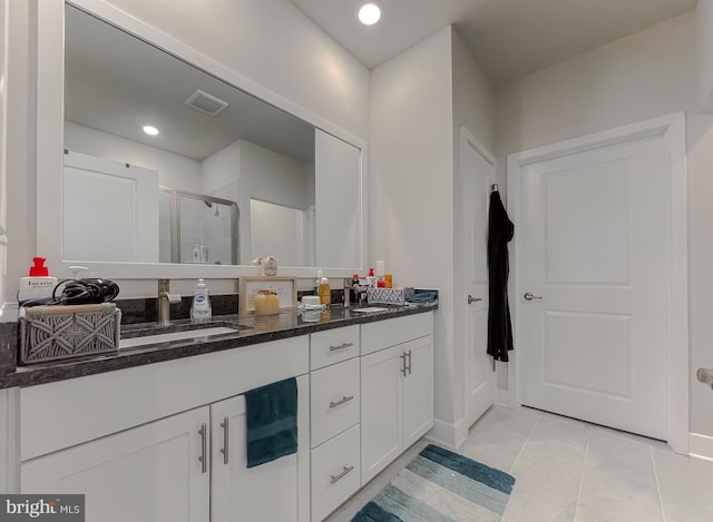 bathroom with vanity and a shower with door