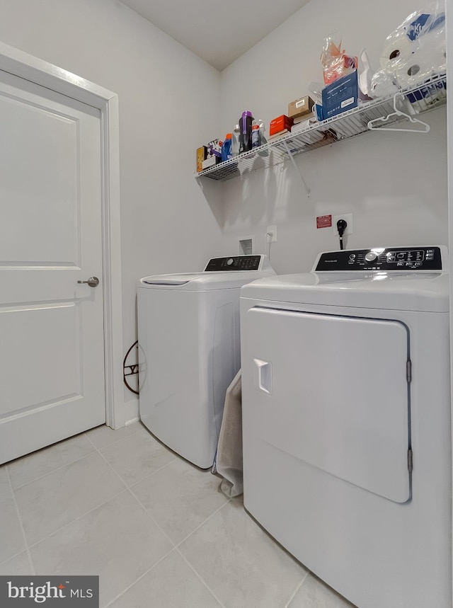 washroom with washer and dryer and light tile patterned floors